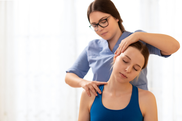 Manual Osteopath adjusting the cervical spine of a client.