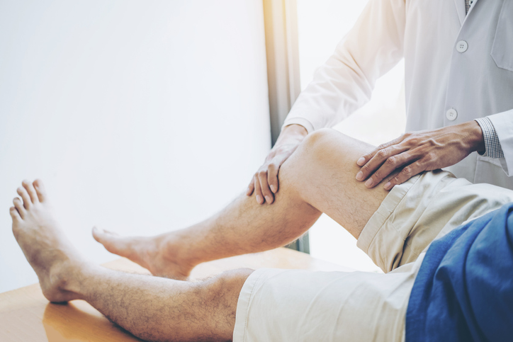 Manual Osteopath adjusting the knee of a client.