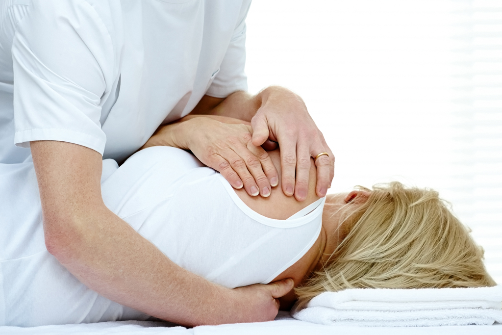 A manual Osteopath working with a client.